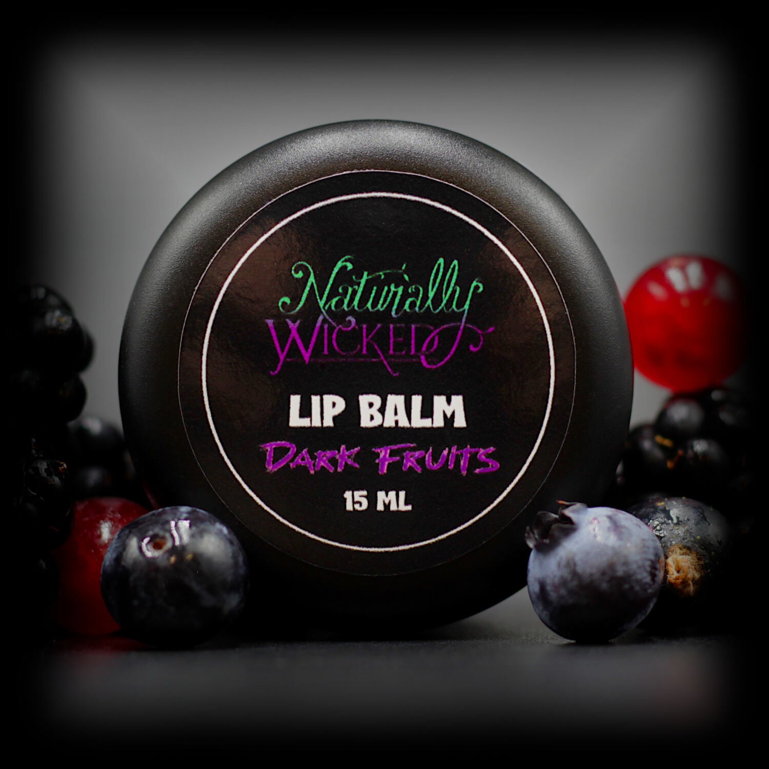 Naturally Wicked Dark Fruits Lip Balm Luxury Lid Surrounded By Ripe & Juicy Dark Berries