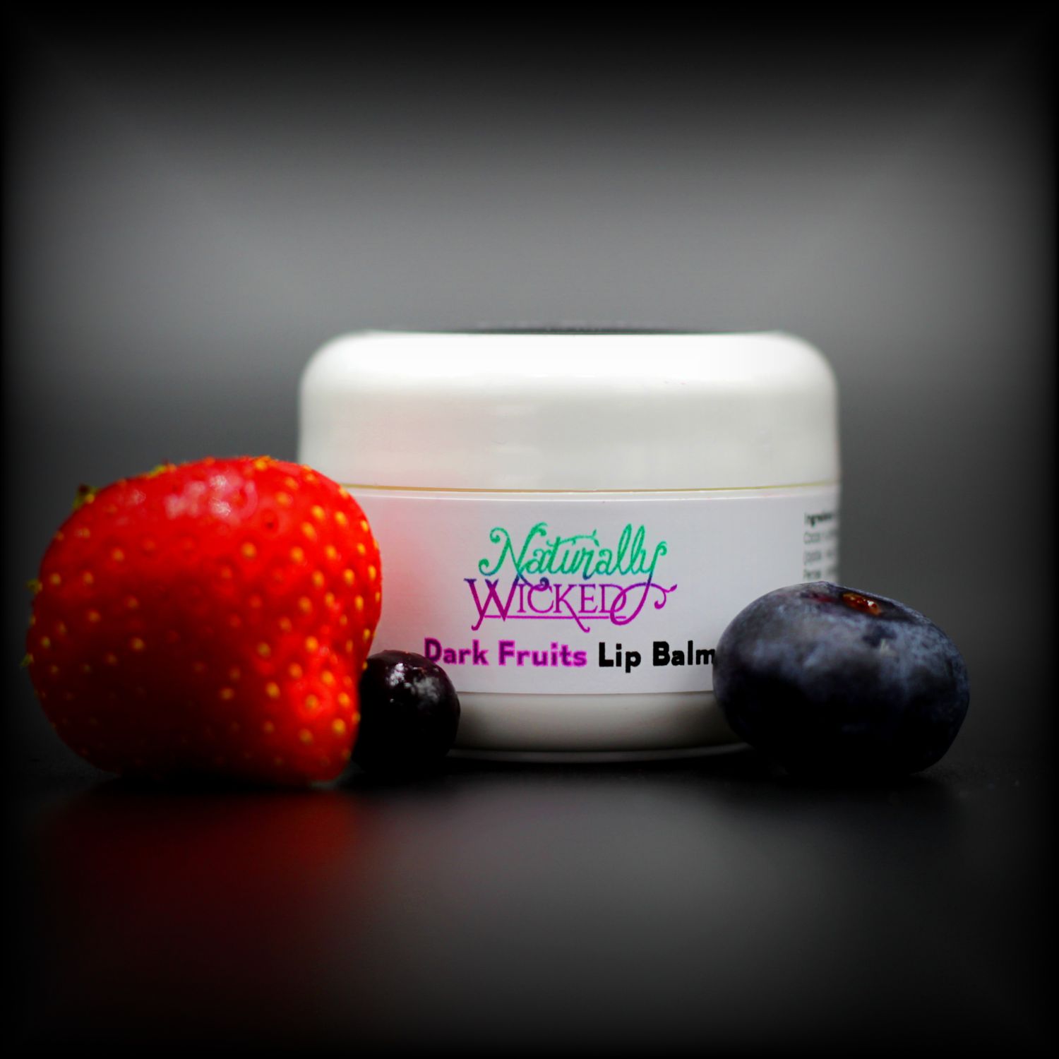 Naturally Wicked Dark Fruits Moisturising Lip Balm Surrounded By Strawberry, Blueberry & Blackcurrant