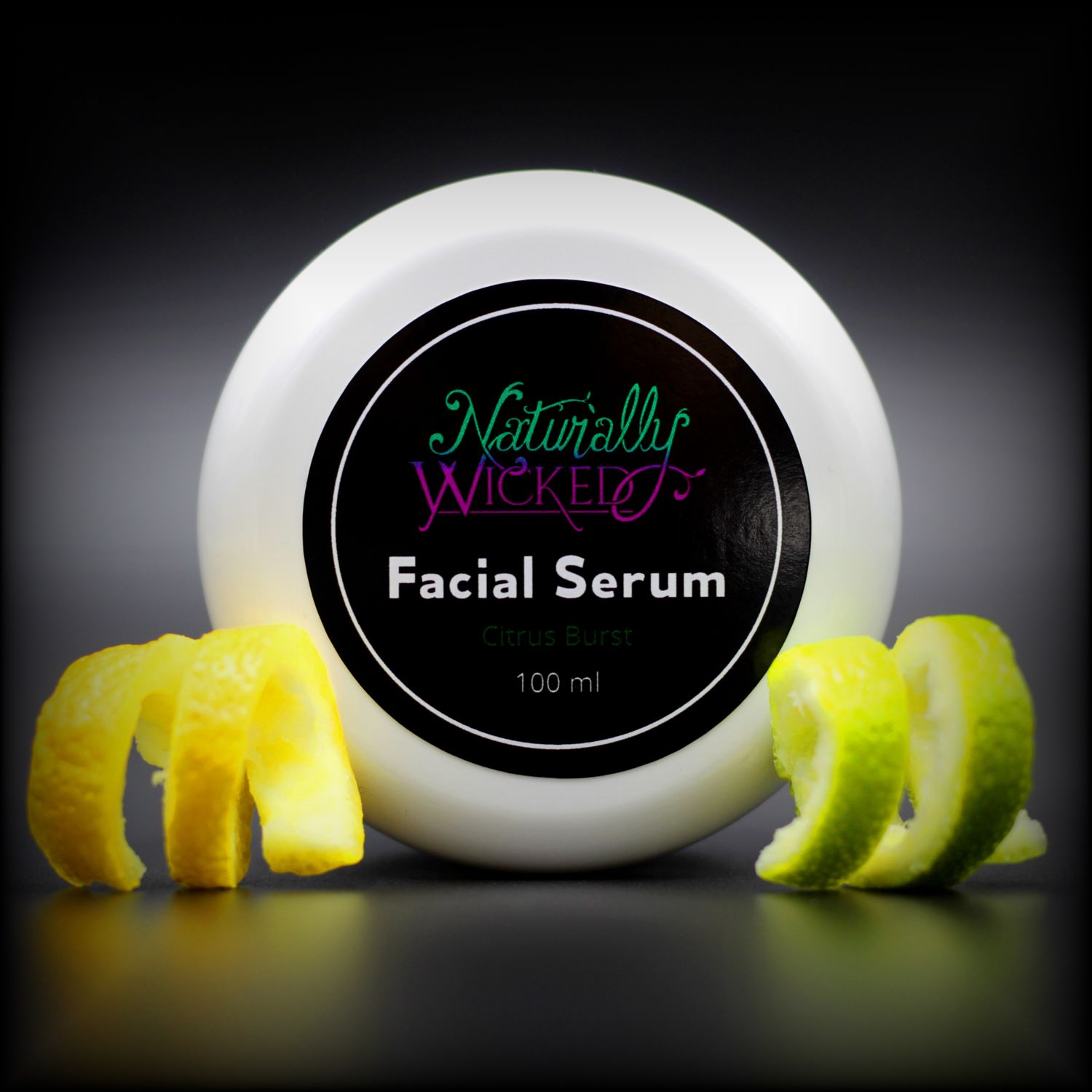 Naturally Wicked Citrus Burst Facial Serum Lid Surrounded By Sliced Yellow Lemon Twist & Sliced Green Lime Twist