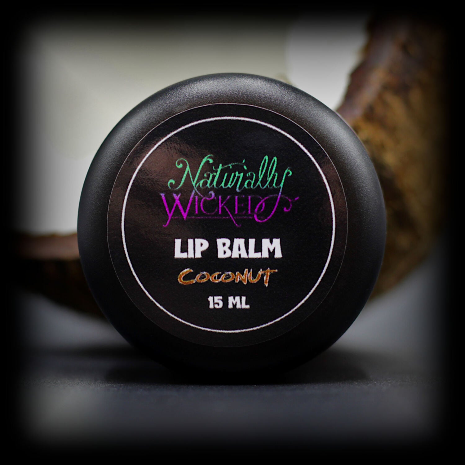 Naturally Wicked Coconut Lip Balm Lid Beside Fleshy Cracked Coconut