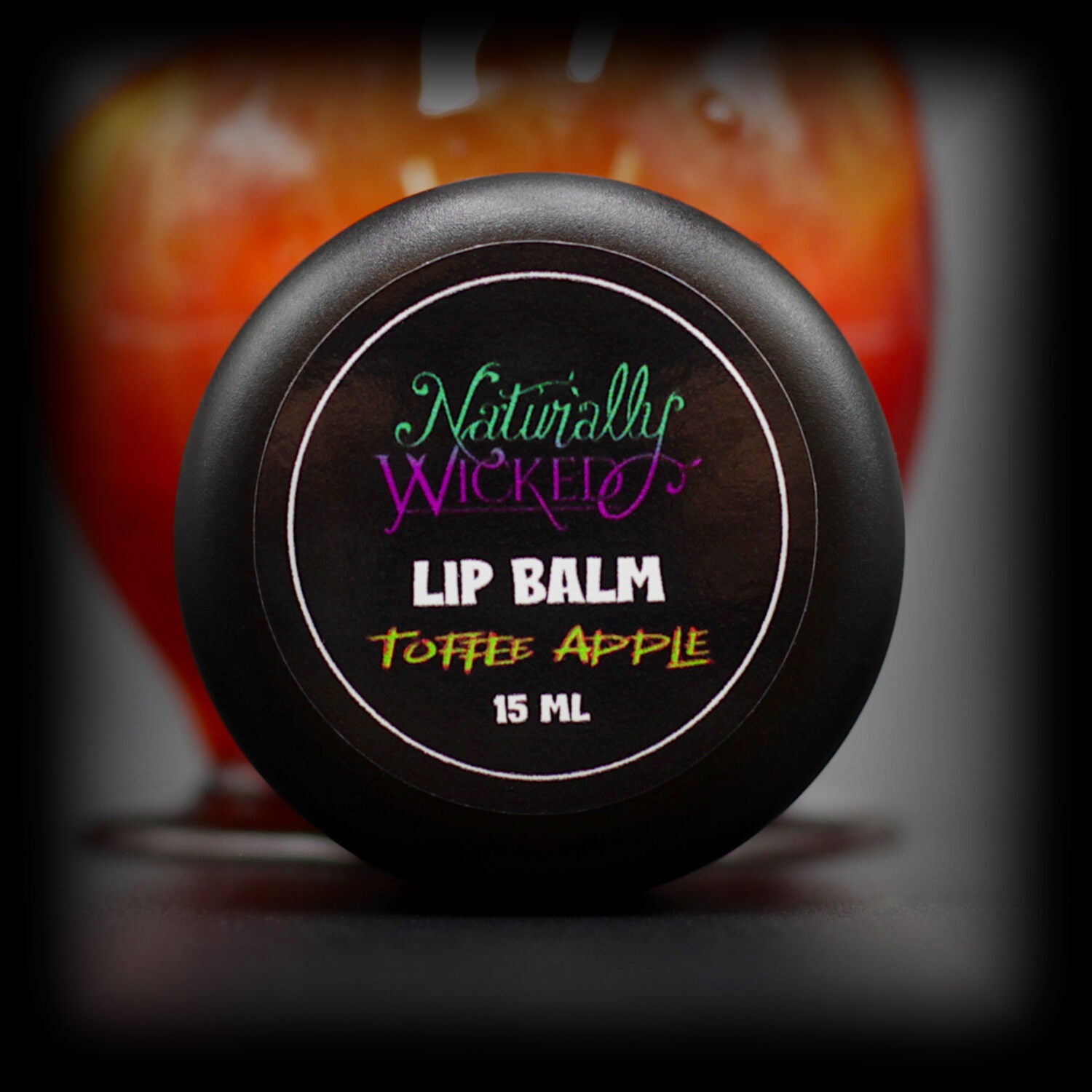 Naturally Wicked Toffee Apple Lip Balm Top Beside Red Toffee Covered Apple