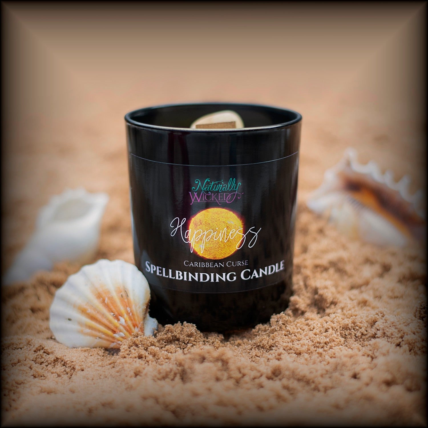 A Scenic View Of The Perfect Spell Candle Situated On A Sandy Shell Beach. Naturally Wicked Spellbinding Happiness Candle Proudly Presents It's Dark Black Gloss Label With A Bright Yellow Sun Lion On The Front. The Candle Features Plant-based Smooth Yellow Wax, A Wood Wick And A Beautiful Citrine Crystal. Happiness Is A Gift For All To Share