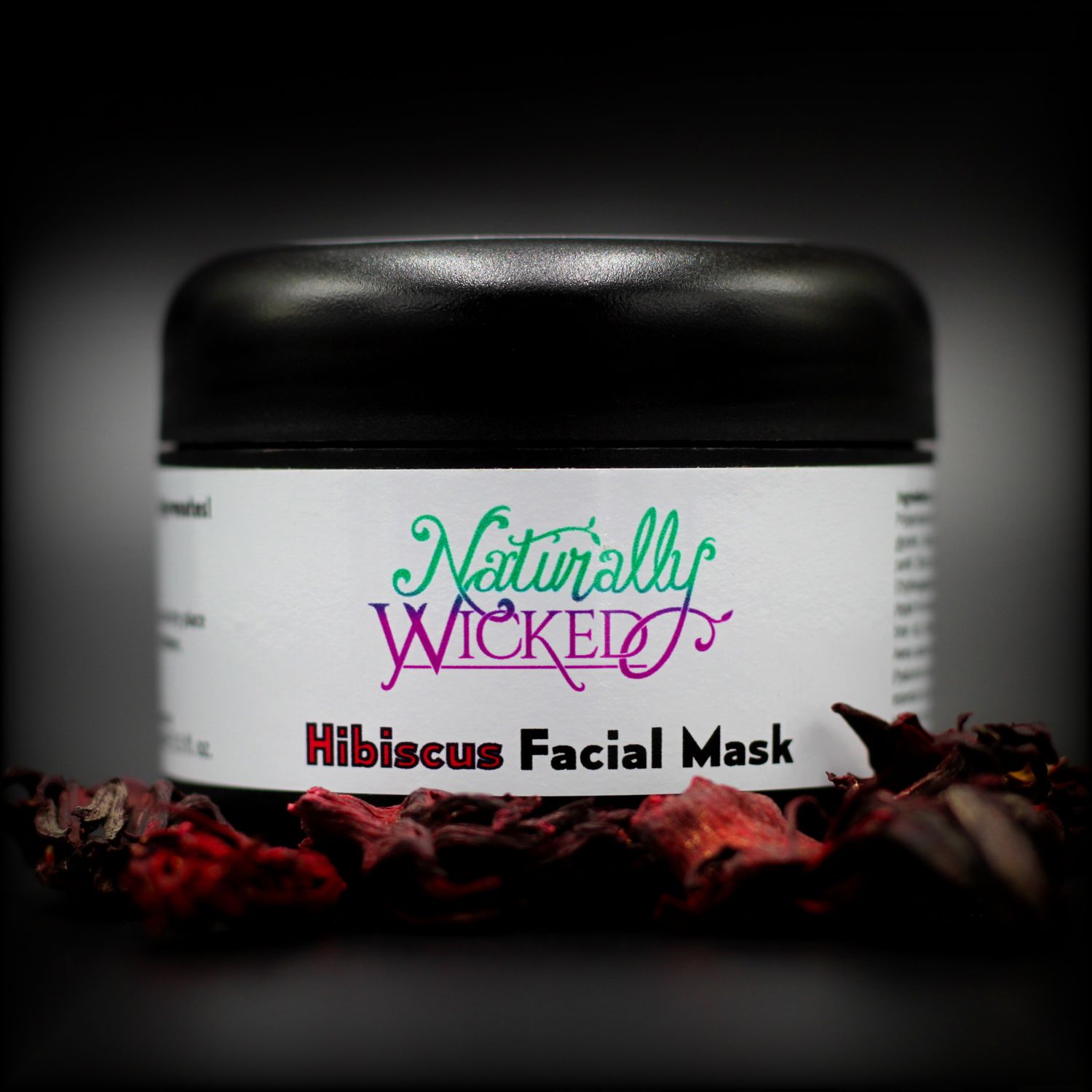 Naturally Wicked Hibiscus Facial Mask Surrounded By Bright Red Firming Hibiscus Flowers