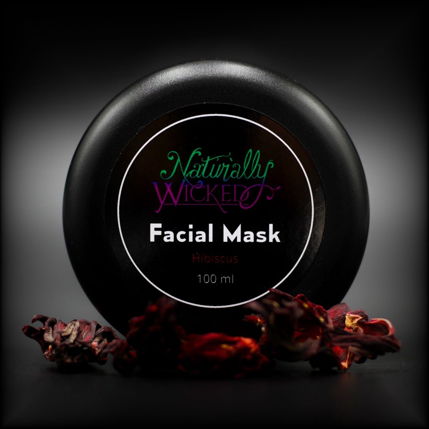 Naturally Wicked Hibiscus Facial Mask Lid Surrounded By Red Hibiscus Flowers
