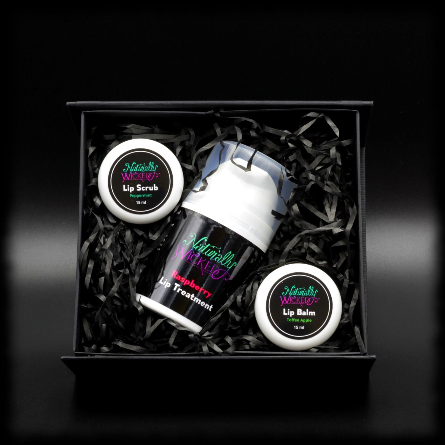 Naturally Wicked Peppermint Lip Scrub, Raspberry Lip Treatment & Toffee Apple Lip Balm Within Black Gift Packaging In Naturally Wicked Original Box