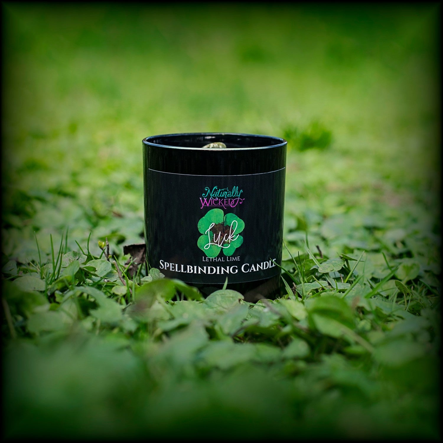 A Scenic View Of The Perfect Spell Candle. Naturally Wicked Spellbinding Luck Candle Proudly Presents It's Dark Black Gloss Label With A  Lucky 4 Leaf Clover On The Front. The Candle Features Plant-based Smooth Green Wax, A Wood Wick And A Beautiful Spotted Epidote Crystal. This Unique Gift Is Perfect For Everyone