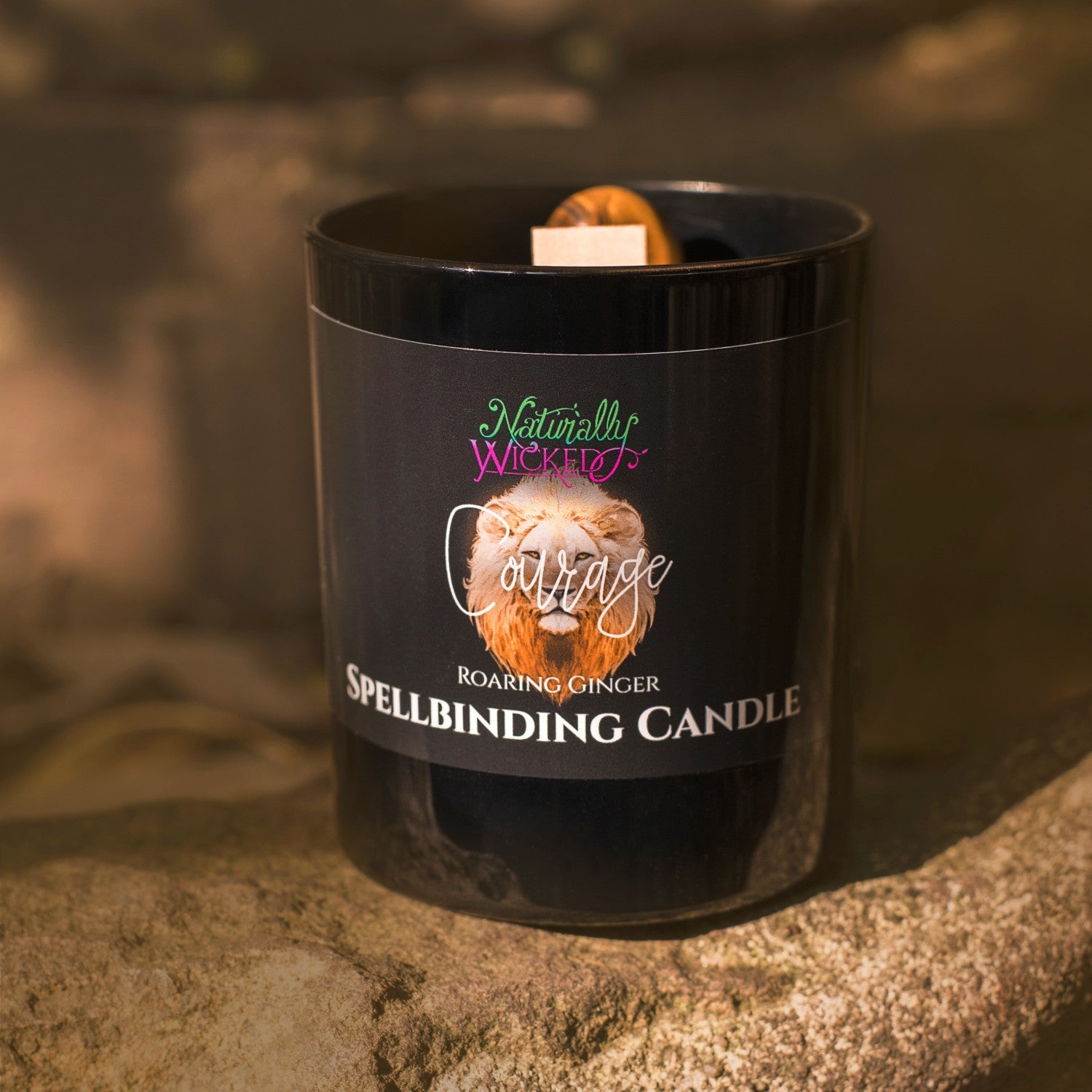 A Scenic View Of The Perfect Spell Candle. Naturally Wicked Spellbinding Courage Candle Proudly Presents It's Dark Black Gloss Label With A Roaring Ginger Lion On The Front.  The Candle Features Plant-based Smooth Brown Wax, A Wood Wick And A Beautiful Tiger's Eye Crystal. A Courageous Gift For All
