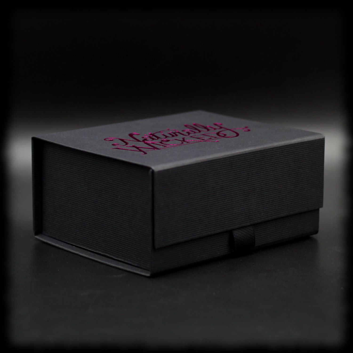 Naturally Wicked Original Black Beauty Box With Pink Metallic Logo In Dark Scene