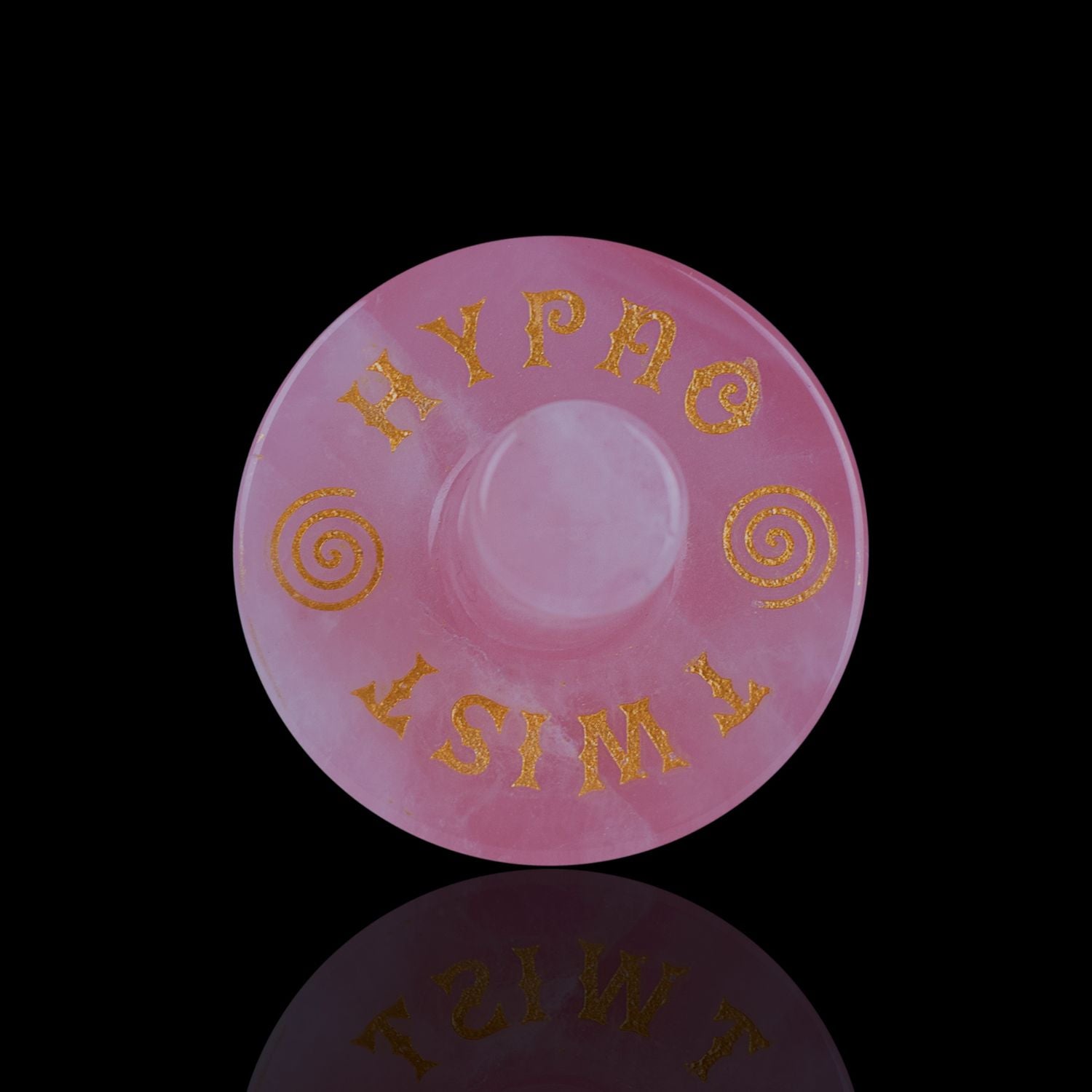 Front View Of The Naturally Wicked Exclusive Hypnotwister. A Rose Quartz Crystal Spinning Top Engraved With Hypno Twist
