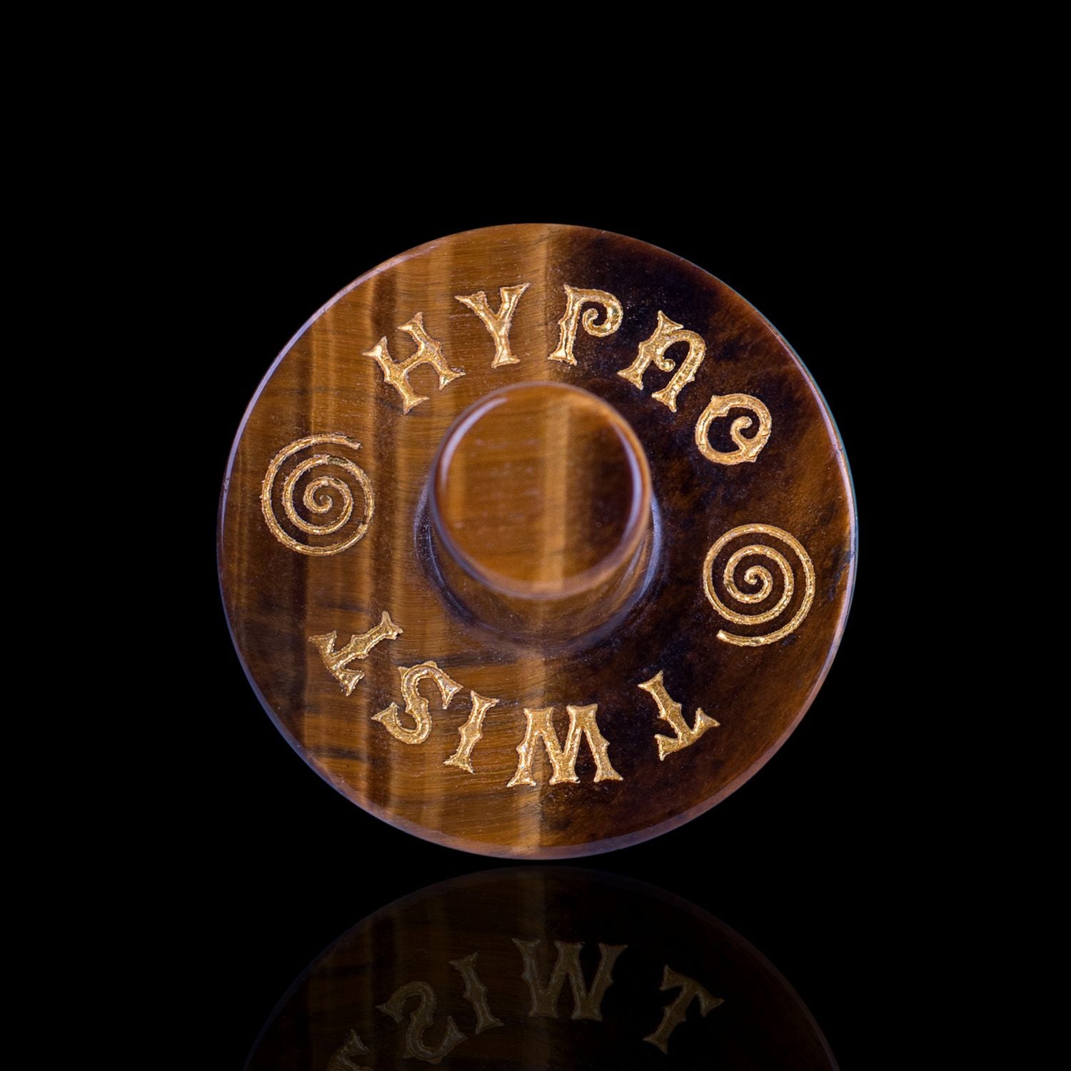 Front View Of The Naturally Wicked Exclusive Hypnotwister. A Tiger's Eye Crystal Spinning Top Engraved With Hypno Twist