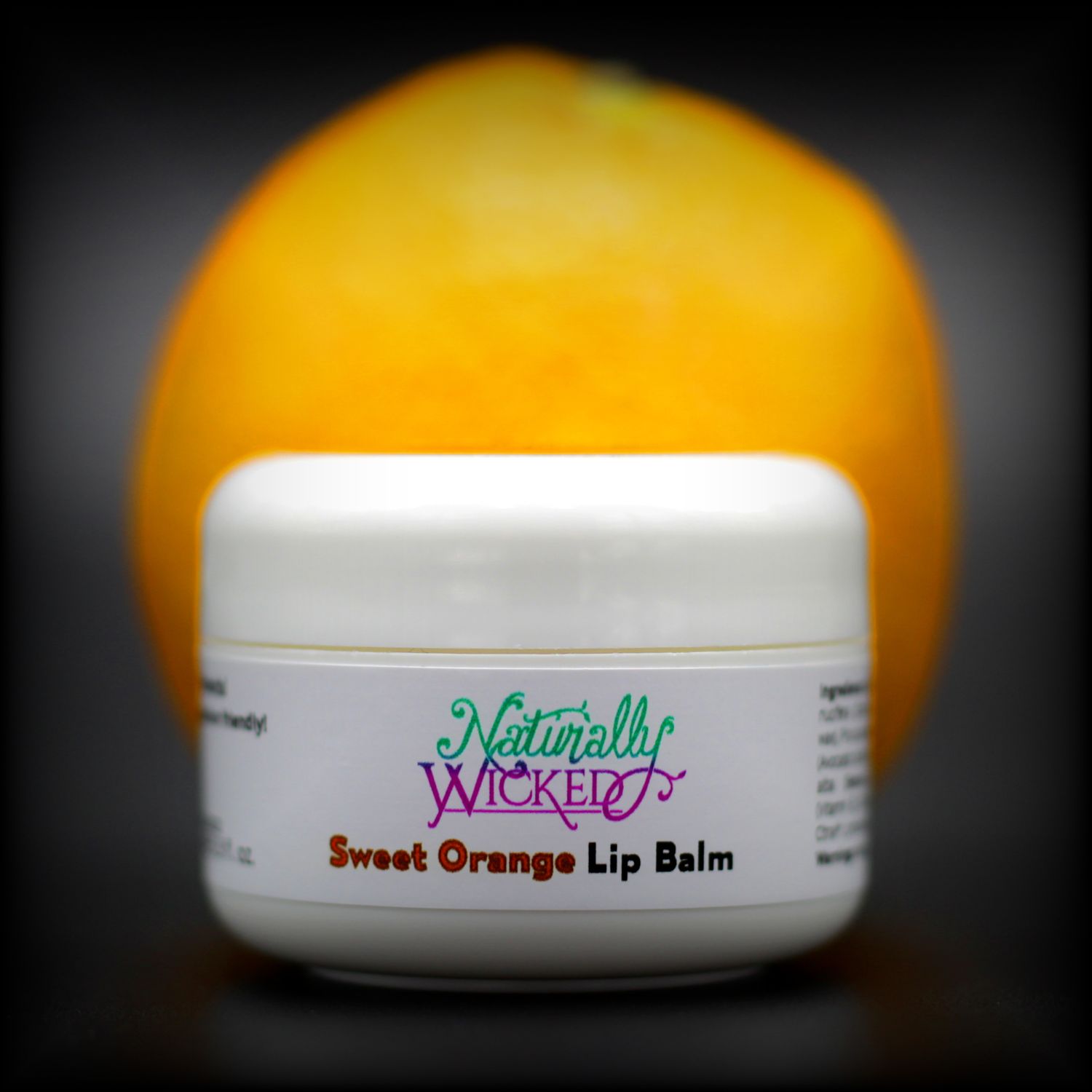 Naturally Wicked Sweet Orange Lip Balm With Illuminous Orange Fruit Behind
