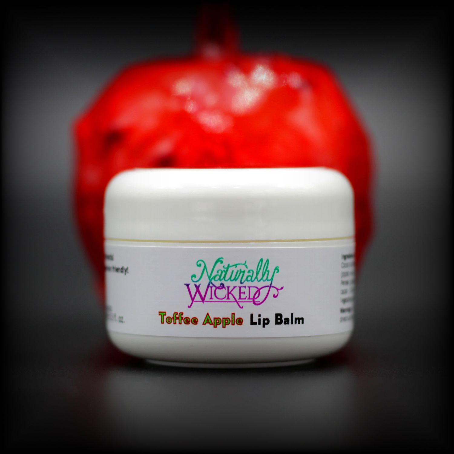 Naturally Wicked Toffee Apple Lip Balm With Bright Red Toffee Apple Behind